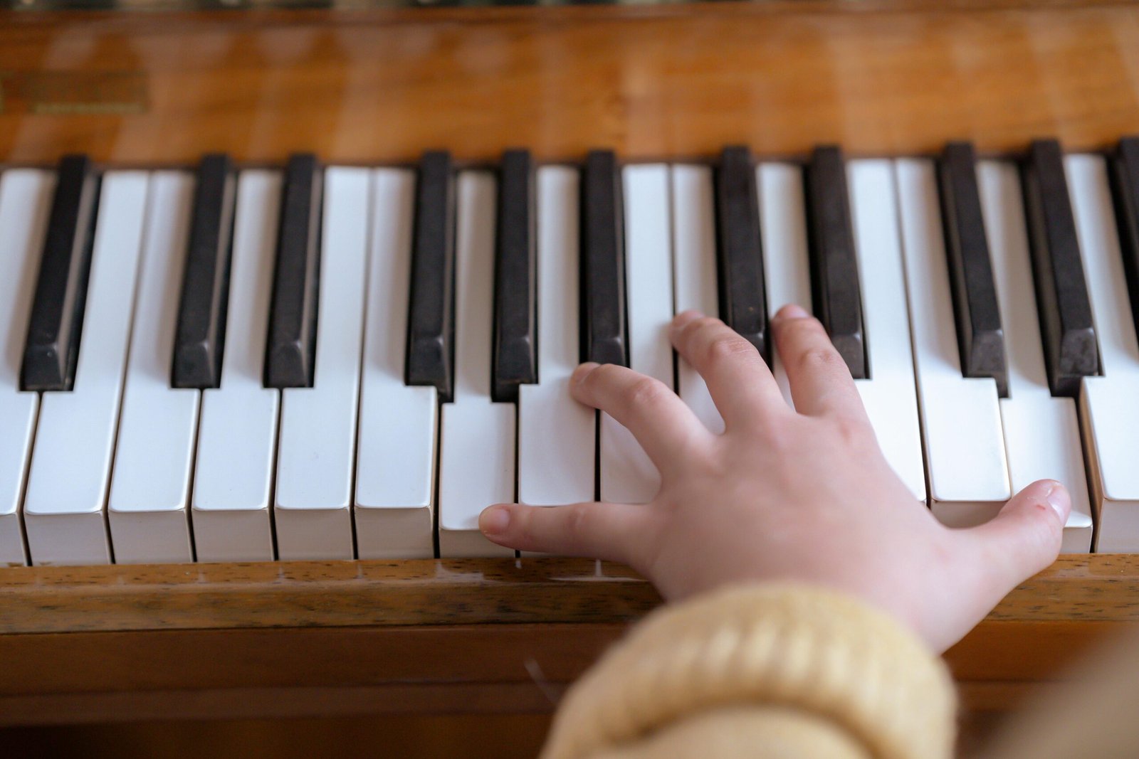 A close-up view of a hand playing on piano keys, demonstrating musical talent and practice.
